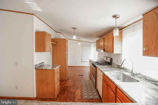 a kitchen with granite countertop a sink a counter top space and cabinets