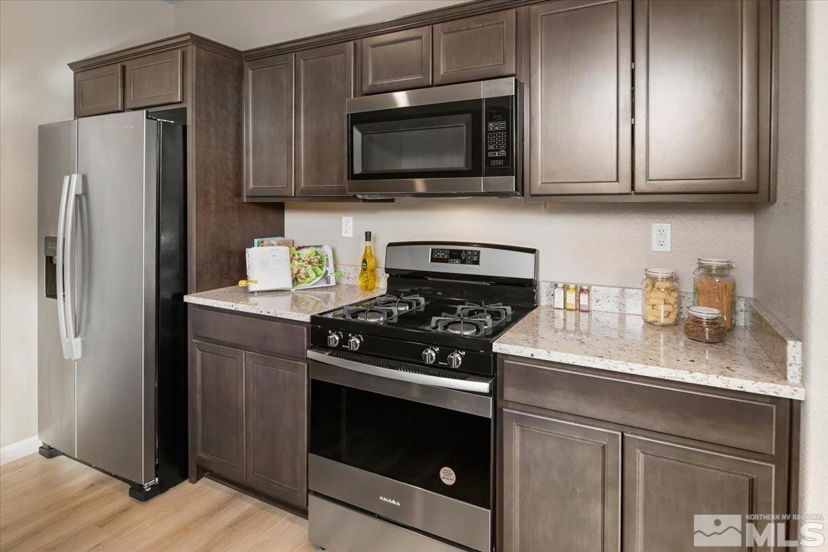 1164 Arrastra Road, Unit LOT 19 Reno, NV 89512 - Photo 14 of 34 a kitchen with stainless steel appliances granite countertop a stove microwave refrigerator and sink