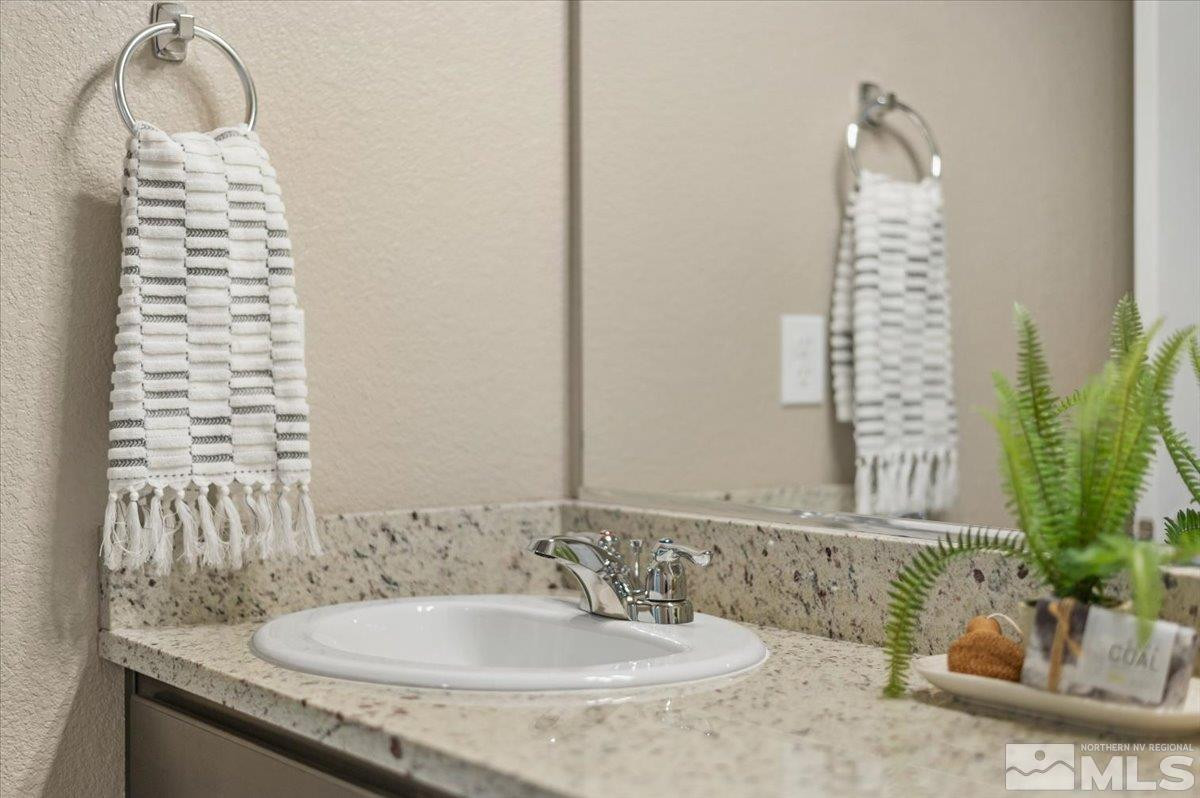 1164 Arrastra Road, Unit LOT 19 Reno, NV 89512 - Photo 31 of 34 a bathroom with a granite countertop sink and a mirror