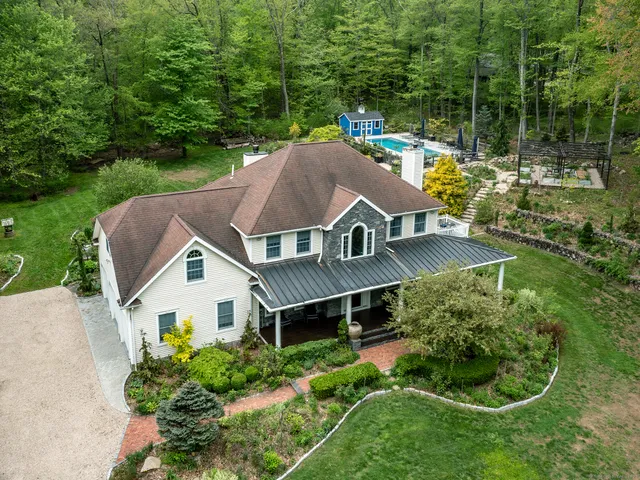 an aerial view of house with yard and green space