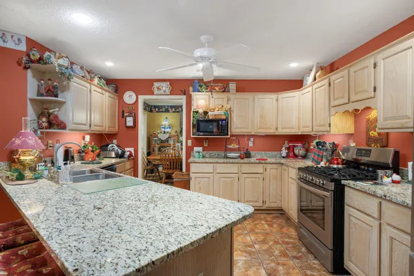 a kitchen with a stove a sink a refrigerator and cabinets