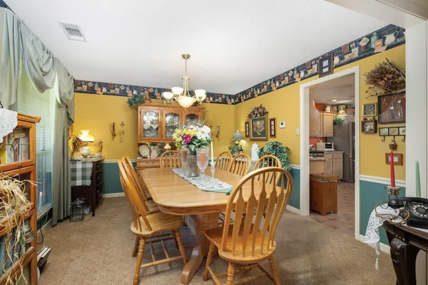 a dining room filled with furniture and chandelier