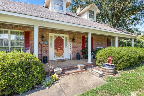 front view of a brick house with potted plants