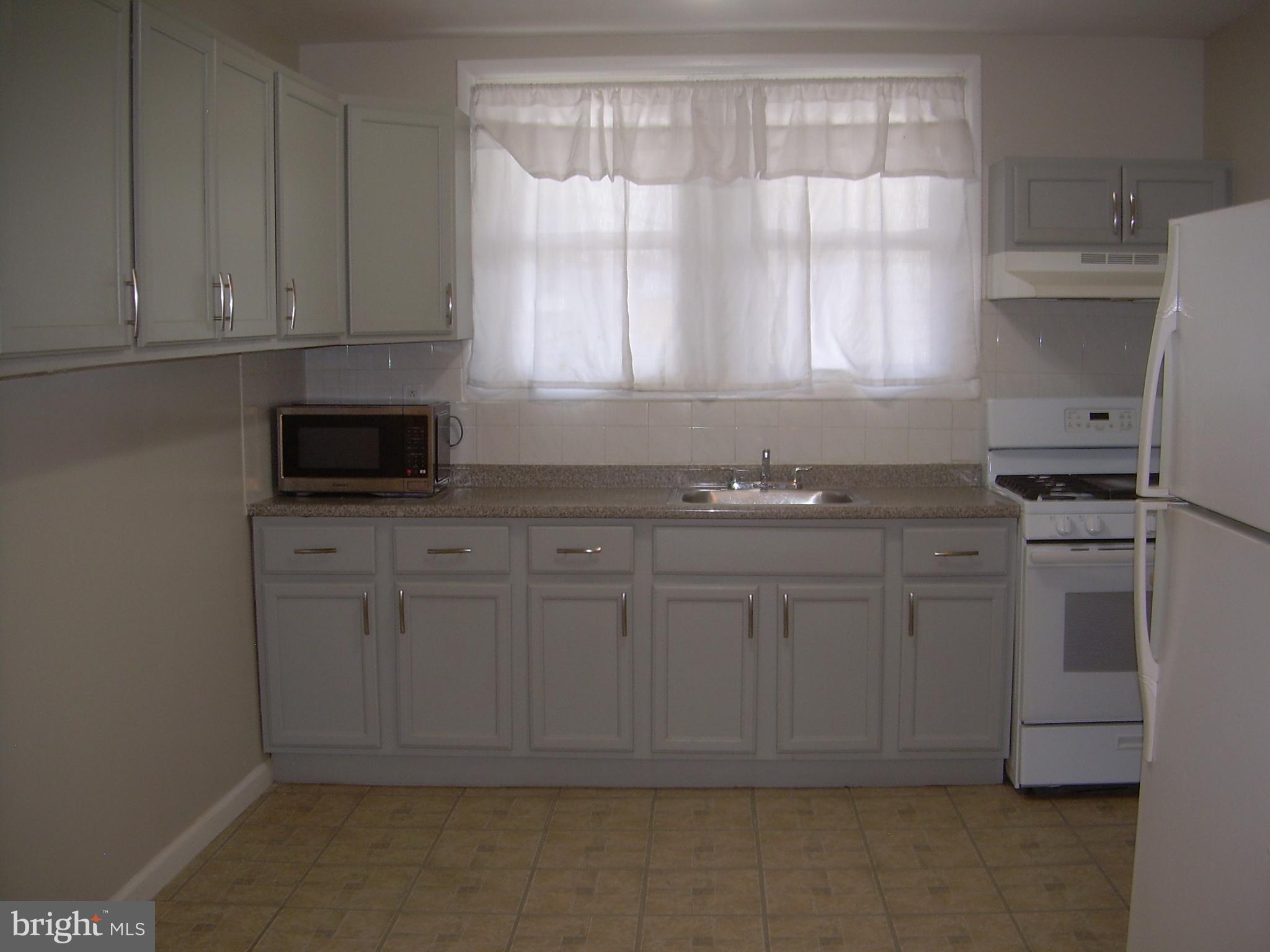 996 Anchor Street Philadelphia, PA 19124 - Photo 7 of 30 a kitchen with granite countertop white cabinets and white appliances