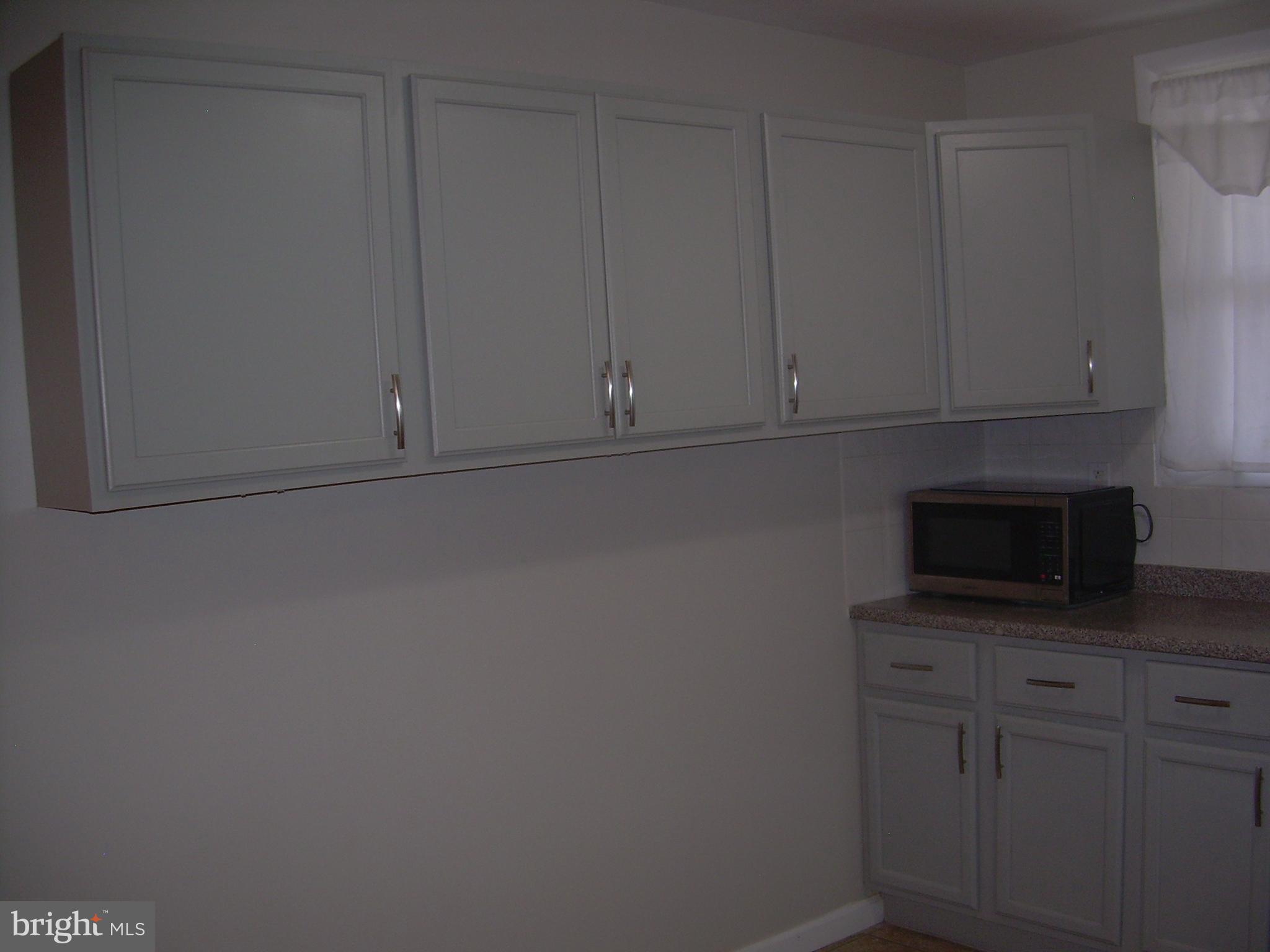 996 Anchor Street Philadelphia, PA 19124 - Photo 8 of 30 a kitchen with white cabinets and a stove top oven
