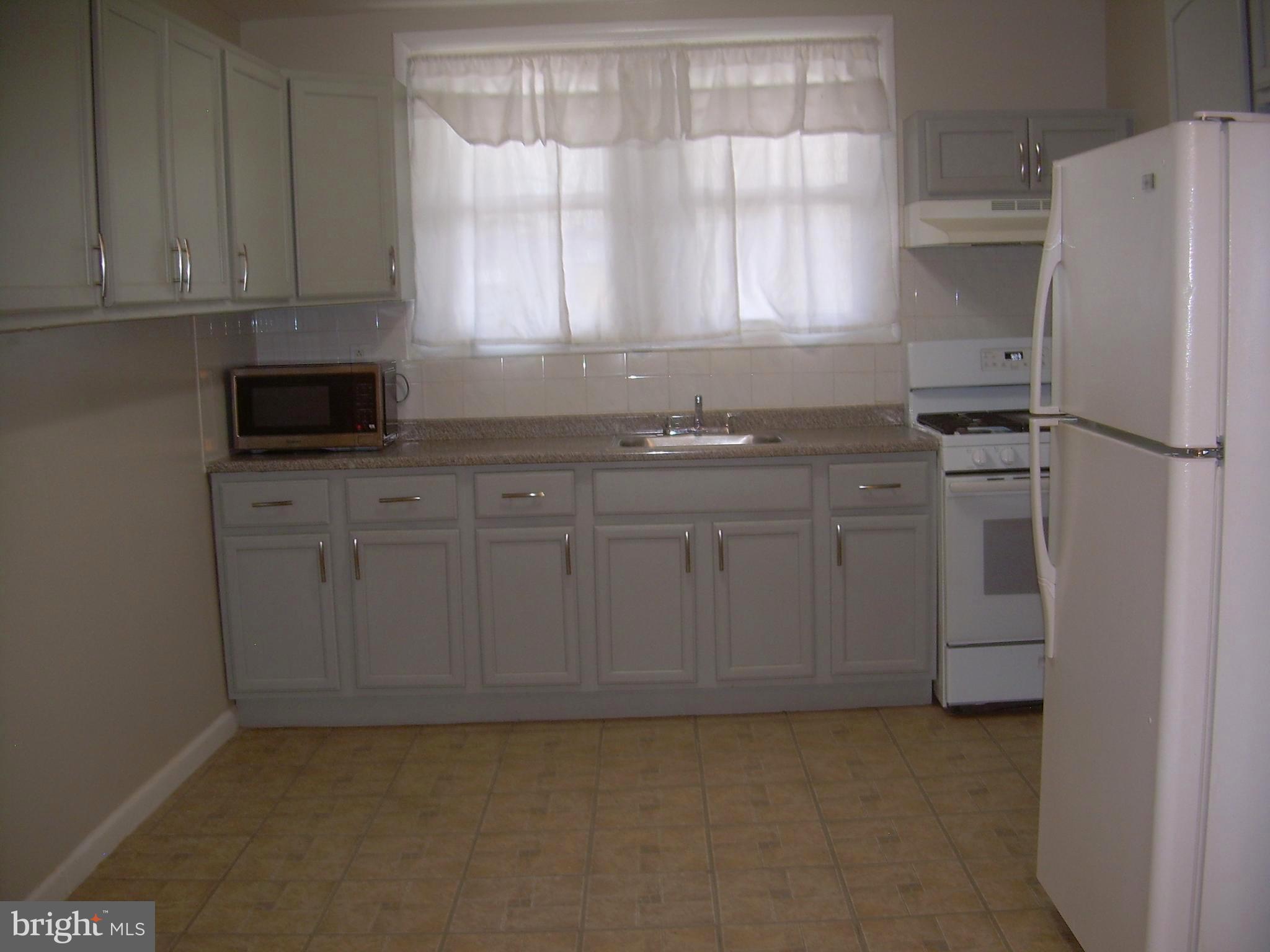 996 Anchor Street Philadelphia, PA 19124 - Photo 9 of 30 a kitchen with stainless steel appliances granite countertop a refrigerator a sink a stove and white cabinets