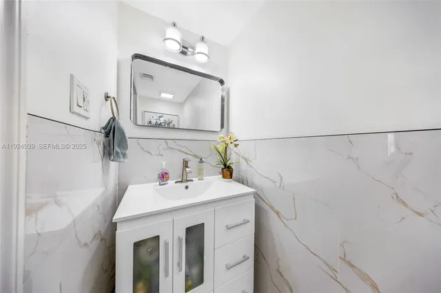 a kitchen with stainless steel appliances a stove a refrigerator a sink a stove cabinets and living room view