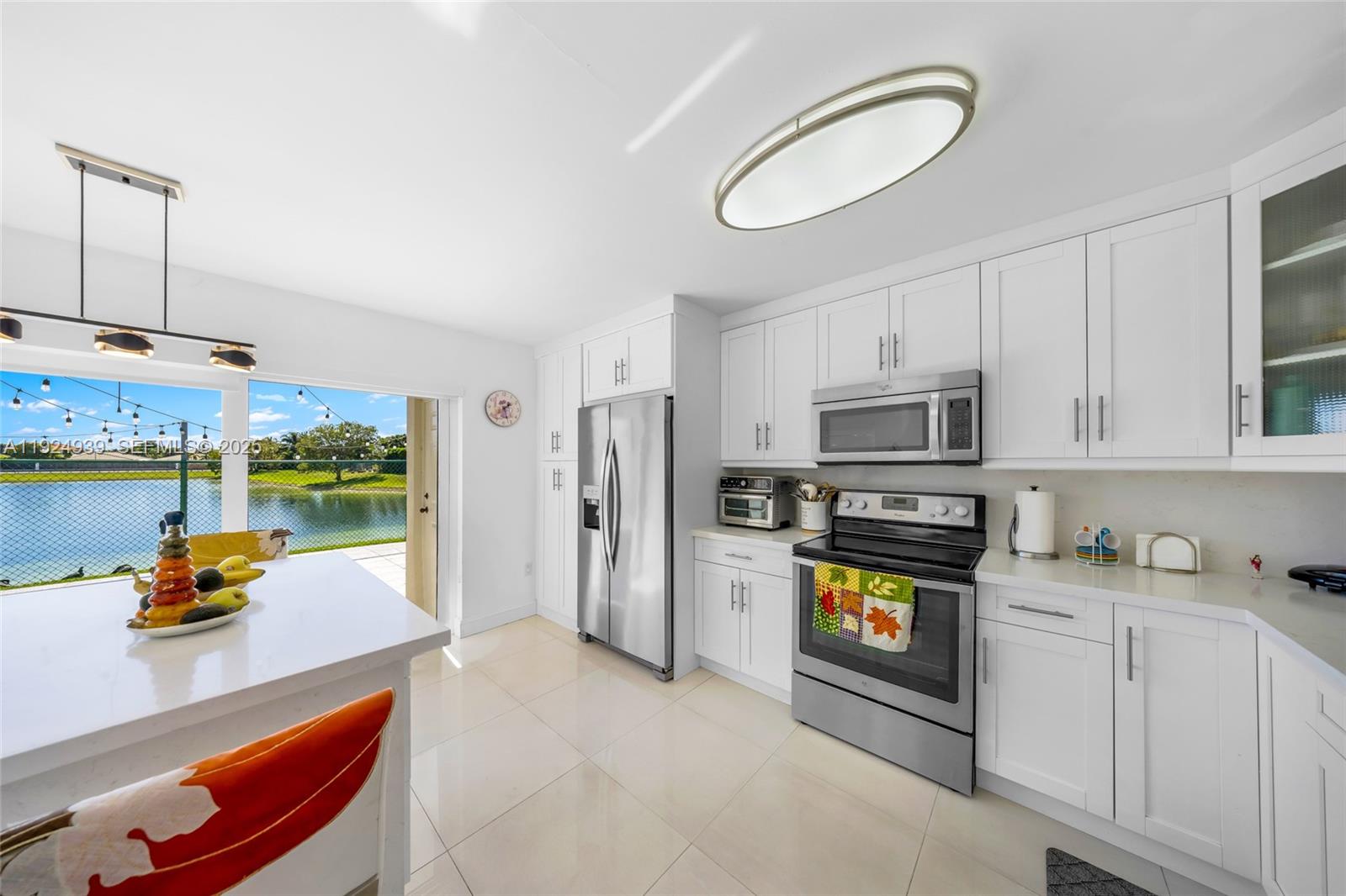 16236 Southwest 75th Street Miami, FL 33193 - Photo 40 of 53 a kitchen with stainless steel appliances a stove a refrigerator a sink a stove cabinets and living room view