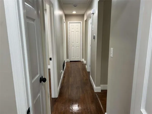 a view of a hallway with wooden floor and staircase
