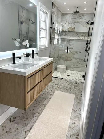 a bathroom with a granite countertop sink a mirror and shower