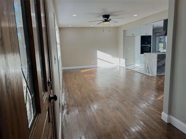a view of a hallway with wooden floor and staircase