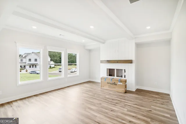 a large white kitchen with wooden floor and a sink