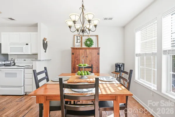 a view of a dining room with furniture a chandelier and wooden floor