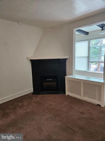 a view of an empty room with a fireplace and a window