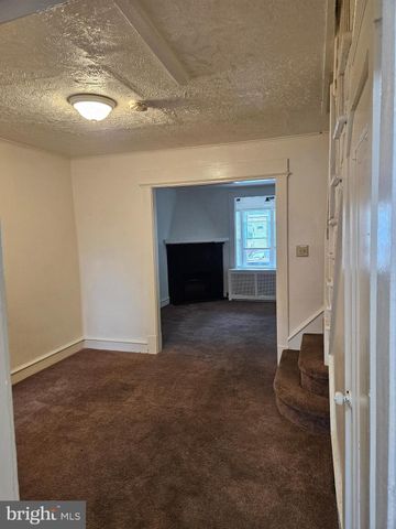 an empty room with a fireplace and window