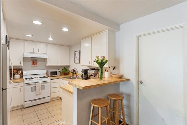 a kitchen with a sink stainless steel appliances and white cabinets
