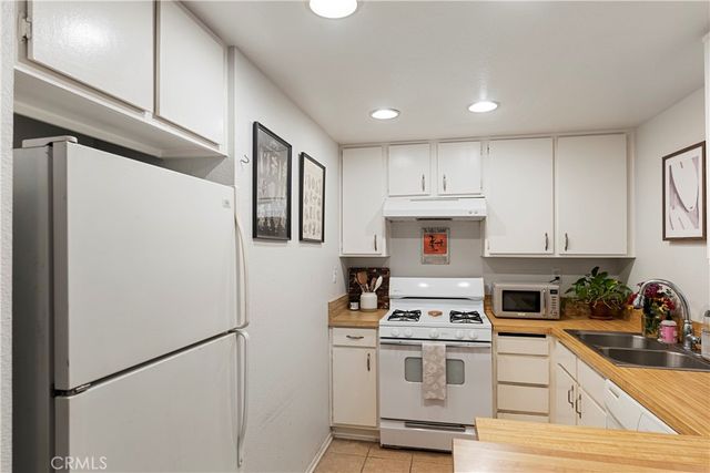 a kitchen with stainless steel appliances granite countertop a refrigerator sink stove and cabinets