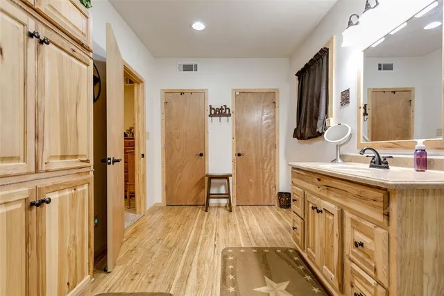 a spacious bathroom with a double vanity sink a mirror and a shower