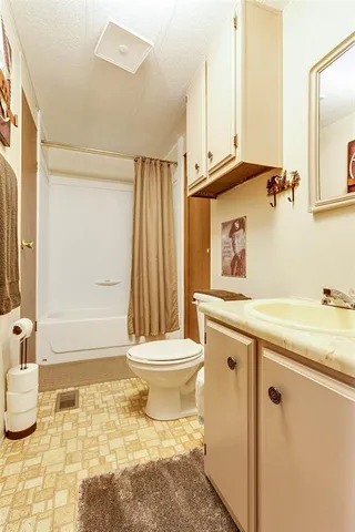 a bathroom with a granite countertop sink toilet and shower