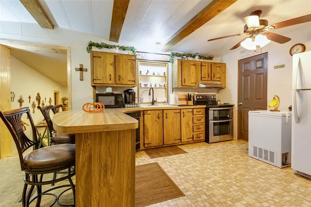 a kitchen that has a sink a table and chairs in it