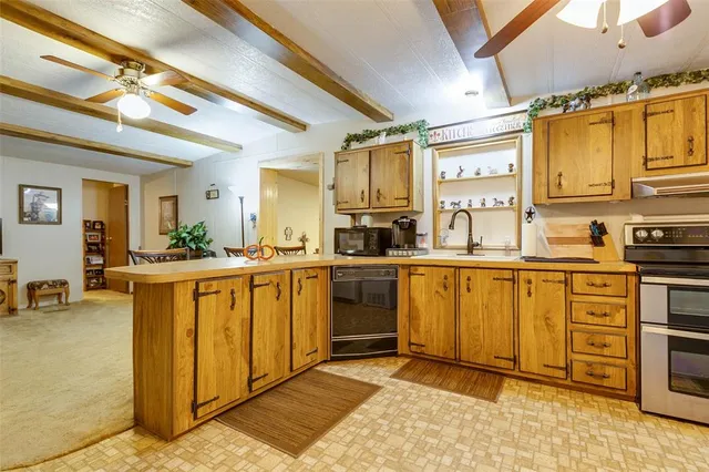 a kitchen with stainless steel appliances granite countertop a sink a stove and cabinets