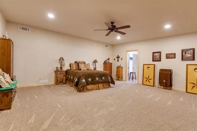 a spacious bedroom with a bed and a flat screen television