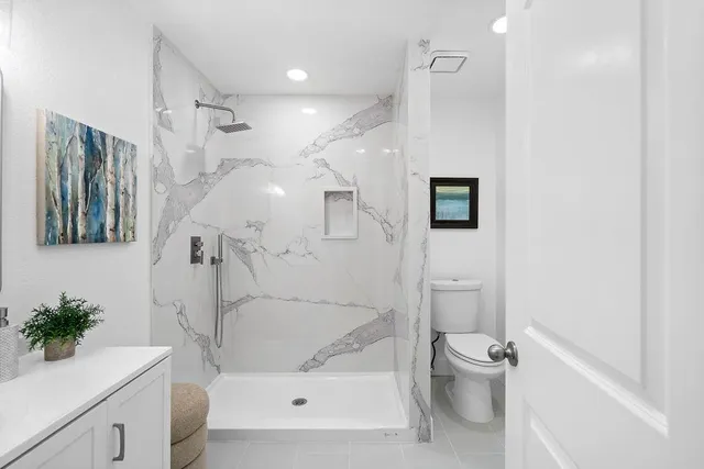 a bathroom with a double vanity sink a toilet and a mirror