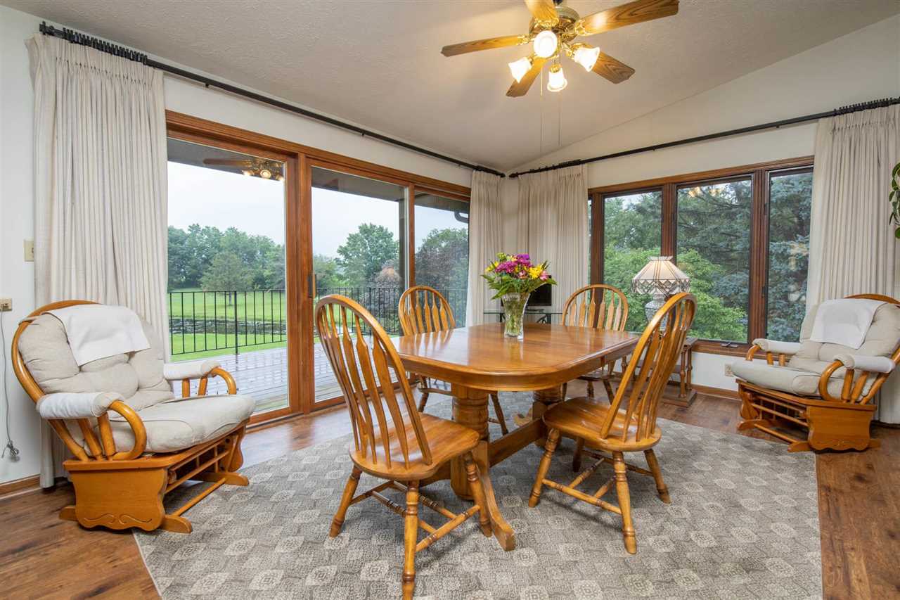 7676 Swanson Road Roscoe, IL 61073 - Photo 19 of 39 a view of a dining room with furniture wooden floor and a chandelier