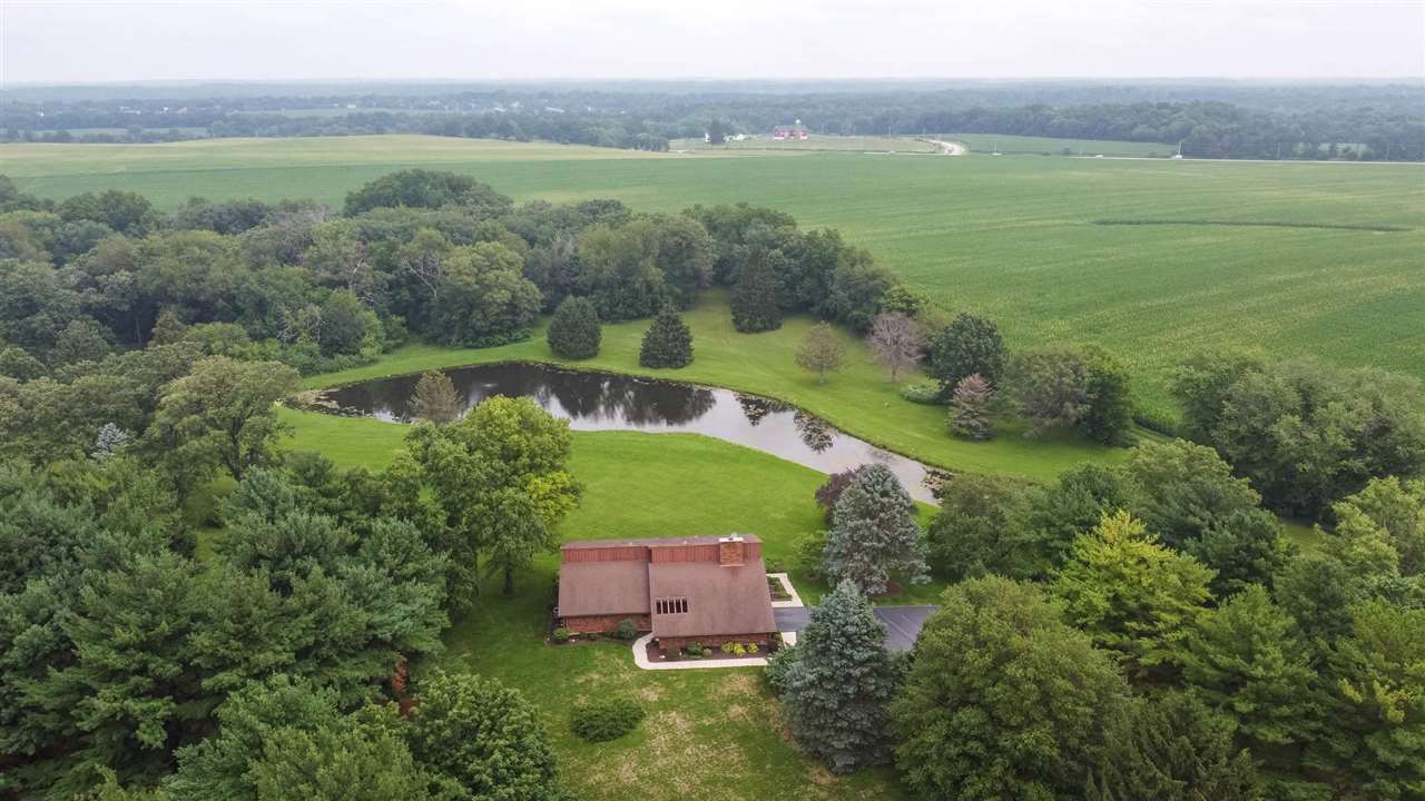 7676 Swanson Road Roscoe, IL 61073 - Photo 2 of 39 a view of a lake with a building in the background