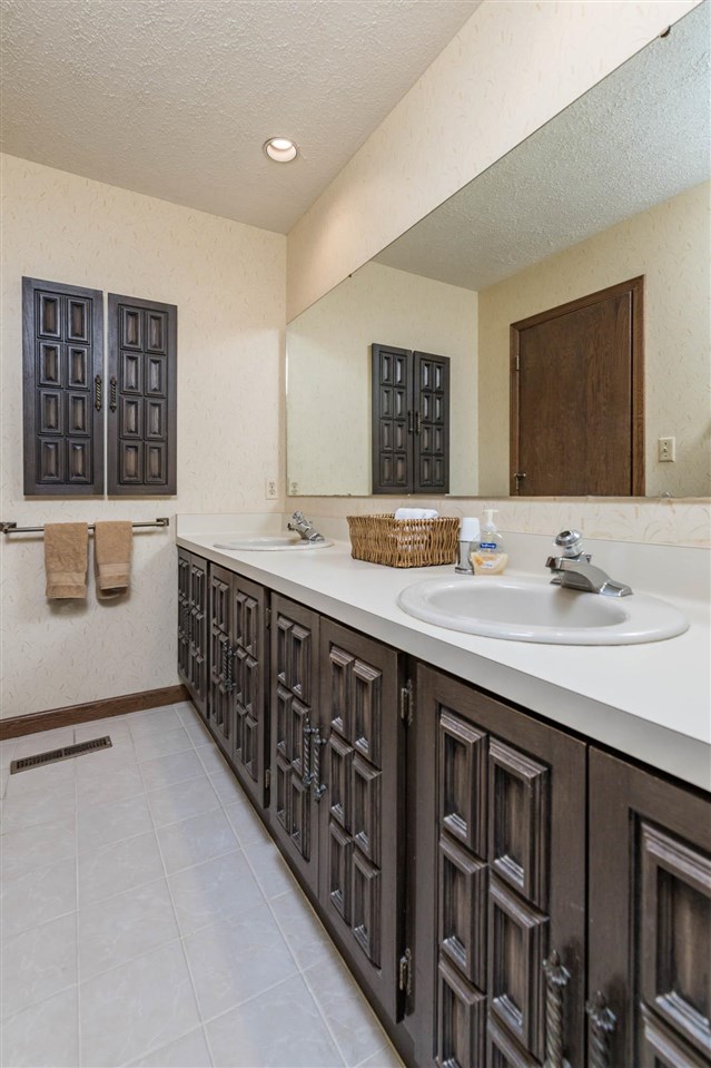 7676 Swanson Road Roscoe, IL 61073 - Photo 31 of 39 a spacious bathroom with a double vanity sink a mirror and a bathtub