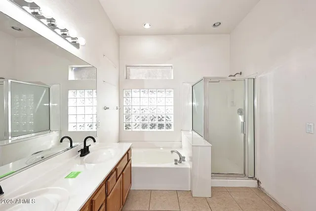 a bathroom with a tub a sink double vanity and window