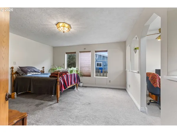 a spacious bedroom with a bed and a chandelier