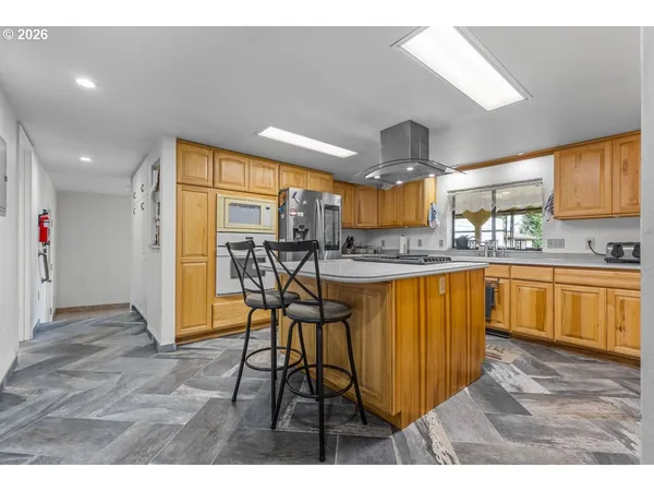 a very nice looking kitchen with a large window appliances and cabinets