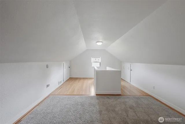 a view of a big room with wooden floor and windows