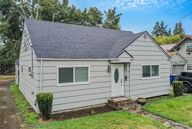 a view of a white house with a small yard and plants