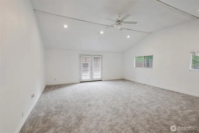 an empty room with a ceiling fan and window