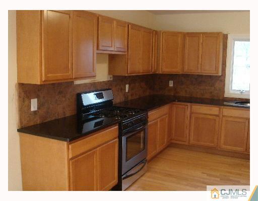 32 Parkerson Road Edison, NJ 08817 - Photo 2 of 4 a kitchen with granite countertop a stove top oven sink and cabinets