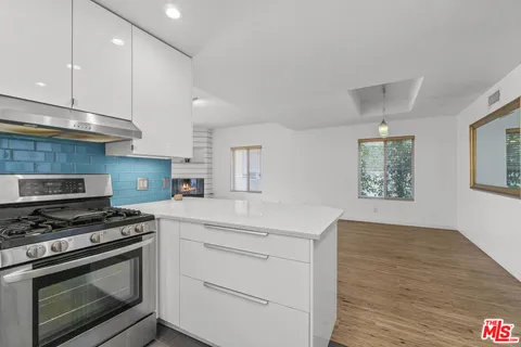 a kitchen with stainless steel appliances white cabinets and a stove a oven with wooden floor