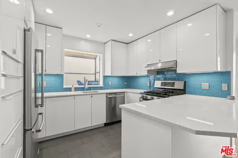 a kitchen with stainless steel appliances a sink stove and refrigerator