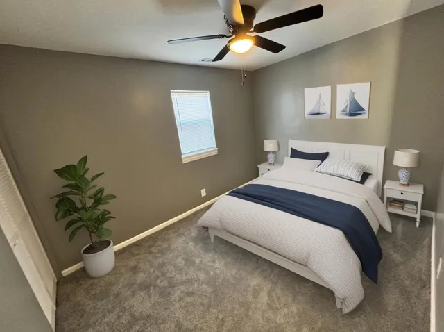 an empty room with a window and a fan