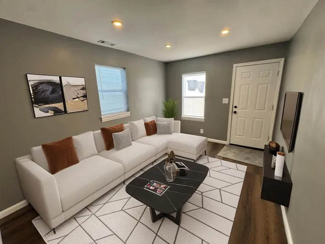 a living room with furniture and a wooden floor