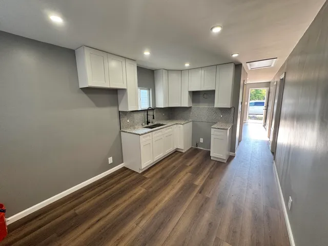 a kitchen with granite countertop white cabinets and white appliances