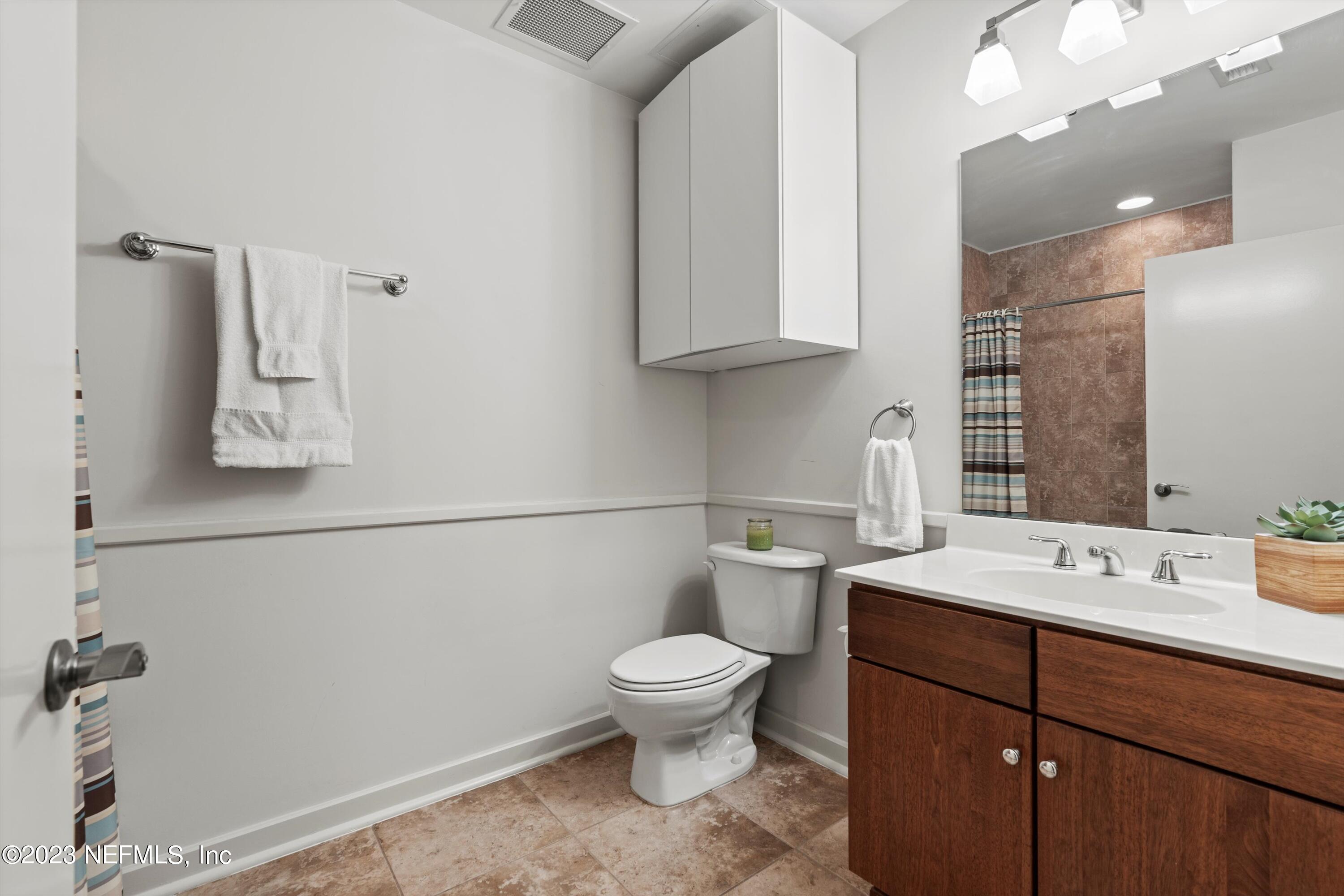 1661 Riverside Avenue, Unit 211 Jacksonville, FL 32204 - Photo 12 of 32 a bathroom with a sink a toilet and mirror