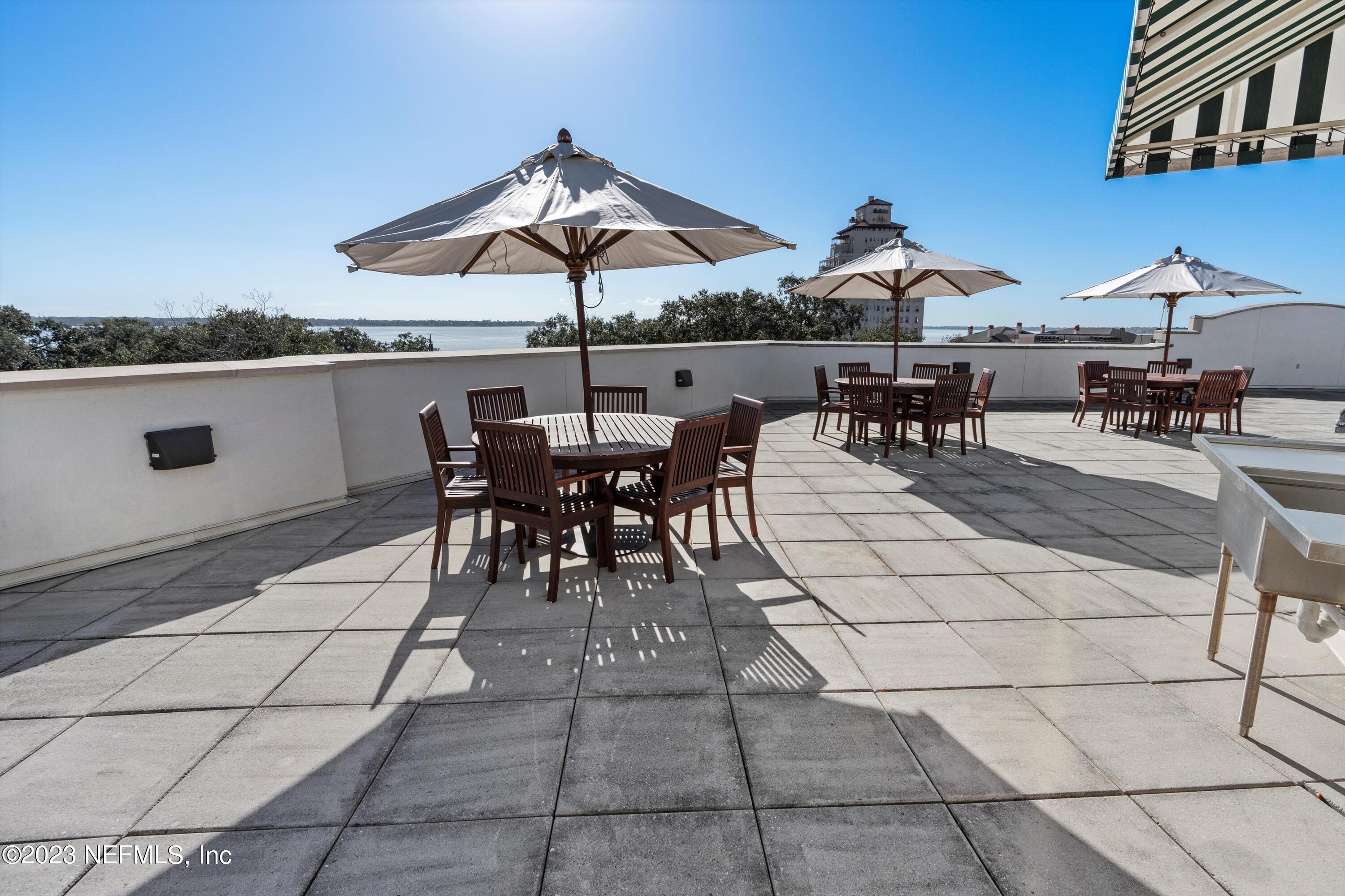 1661 Riverside Avenue, Unit 211 Jacksonville, FL 32204 - Photo 22 of 32 a view of a patio with a dining table and chairs under an umbrella