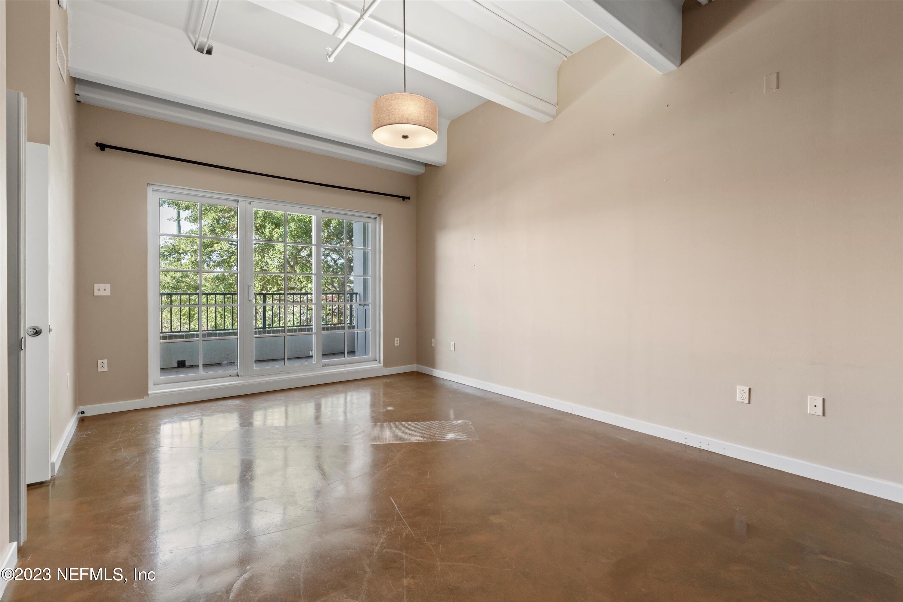 1661 Riverside Avenue, Unit 211 Jacksonville, FL 32204 - Photo 5 of 32 an empty room with wooden floor and windows