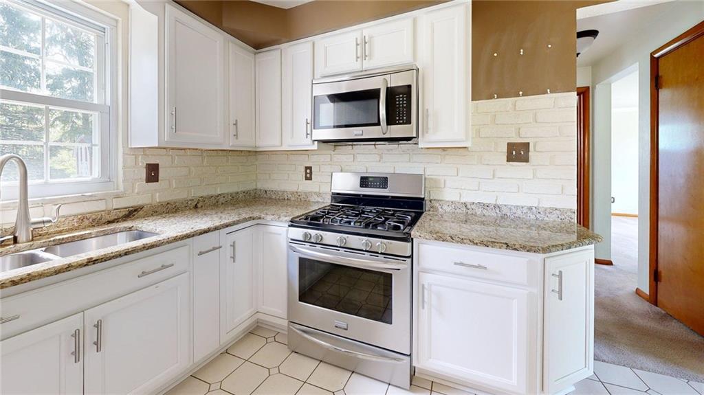 121 Rosemont Drive Coraopolis, PA 15108 - Photo 4 of 29 a kitchen with granite countertop white cabinets and white appliances