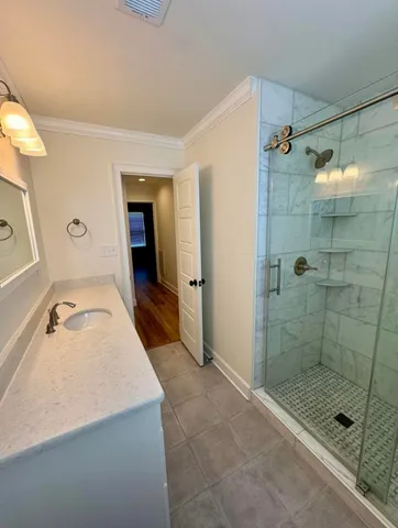 a bathroom with a granite countertop sink a mirror and shower