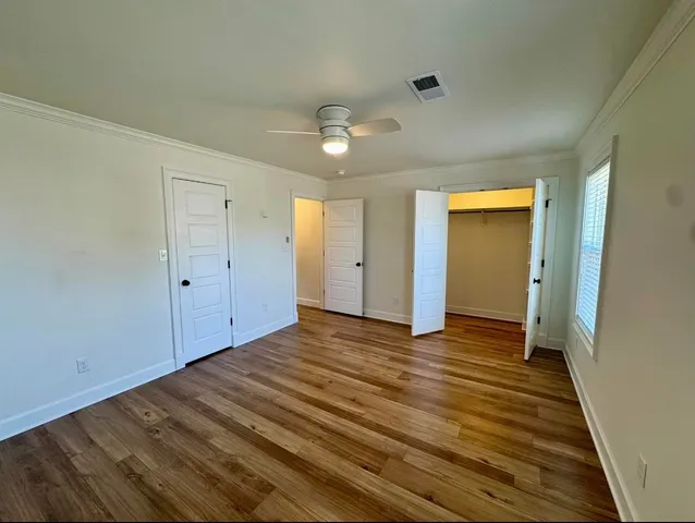 a view of an empty room with wooden floor