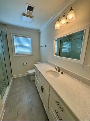 a bathroom with a granite countertop sink a toilet and mirror