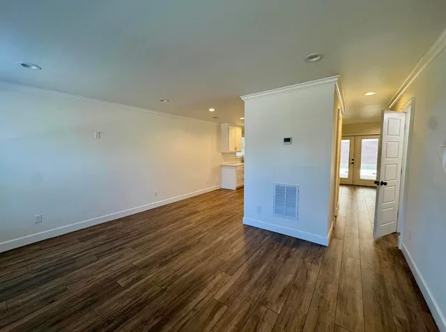 a view of empty room with wooden floor